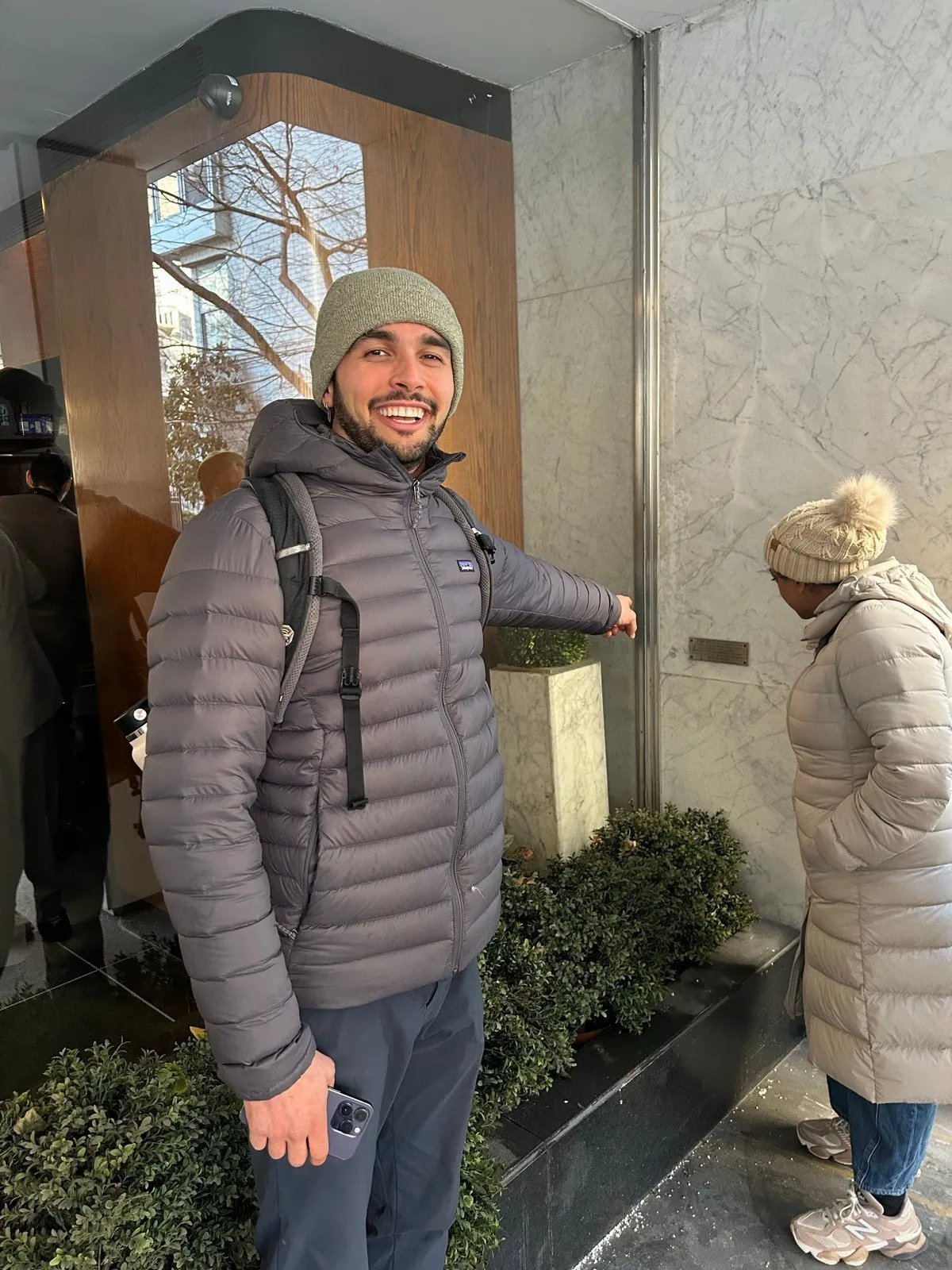 Alex Raphaël smiling, wearing a beanie and puffer jacket